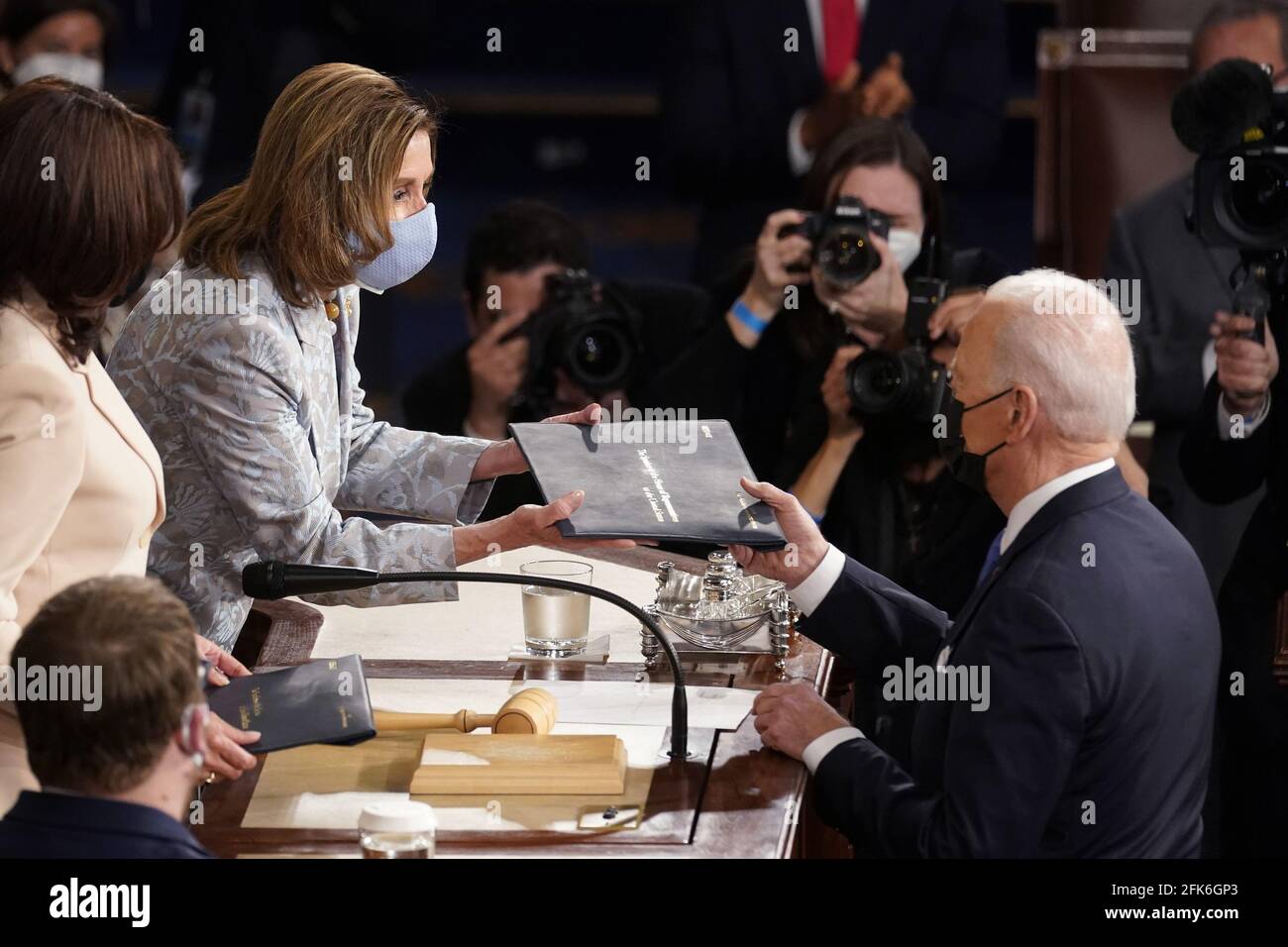 Washington, United States. 28th Apr, 2021. President Joe Biden hands a copy of his speech to House Speaker Nancy Pelosi of Calif., as Vice President Kamala Harris watches before Biden delivers his first joint address to a session of Congress at the U.S. Capitol in Washington DC, on Wednesday, April 28, 2021. Pool photo by Andrew Harnik/UPI Credit: UPI/Alamy Live News Stock Photo