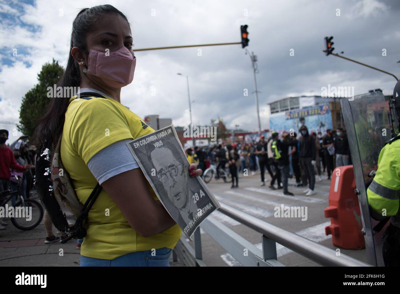 Bogota, Cundinamarca, Colombia. 28th Apr, 2021. A demonstrator holds a sign that reads 'In Colombia there was a virus before the pandemic' with an image of former president Alavaro Uribe Velez demonstrations rise against the tributary reform of president Ivan Duque on April 28, 2021, demonstrations rised to clashes between police and demonstrators. Credit: Daniel Santiago Romero Chaparro/LongVisual/ZUMA Wire/Alamy Live News Stock Photo