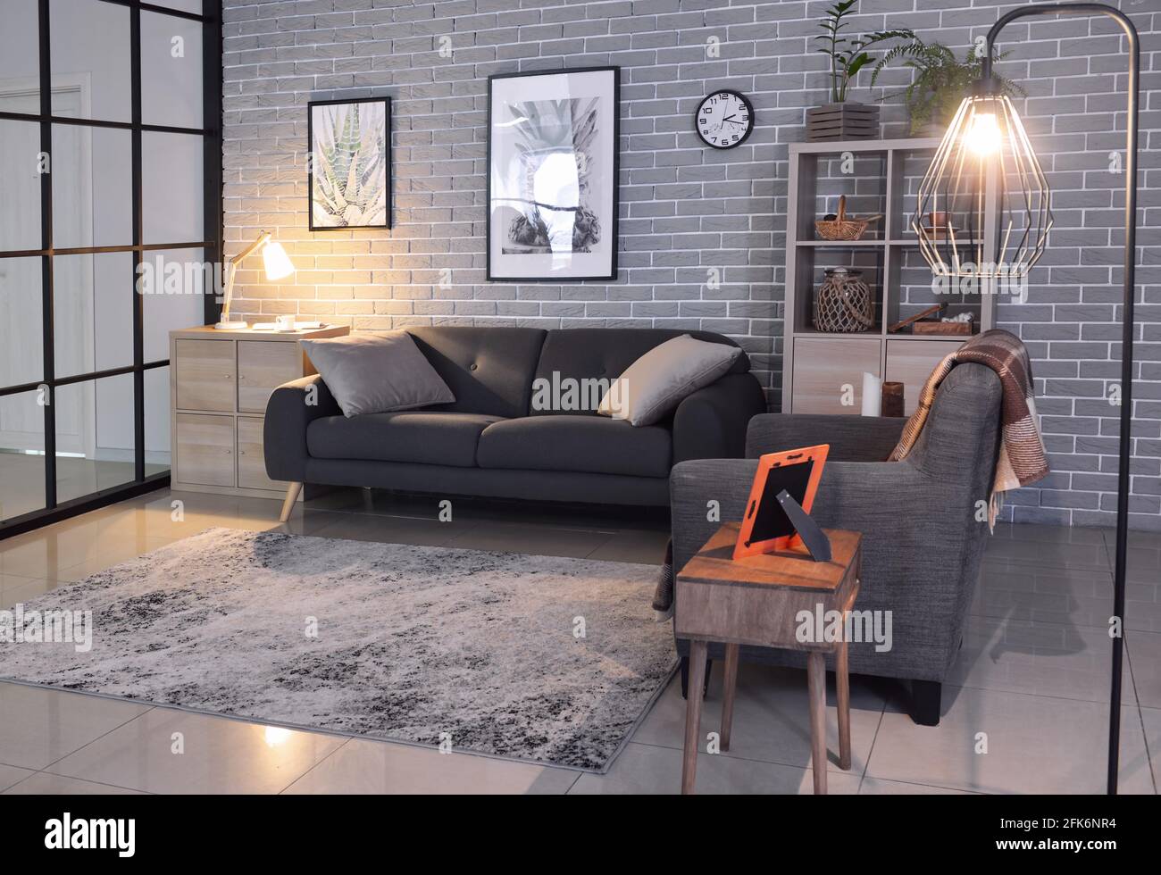 Interior of stylish living room with sofa and armchair Stock Photo - Alamy