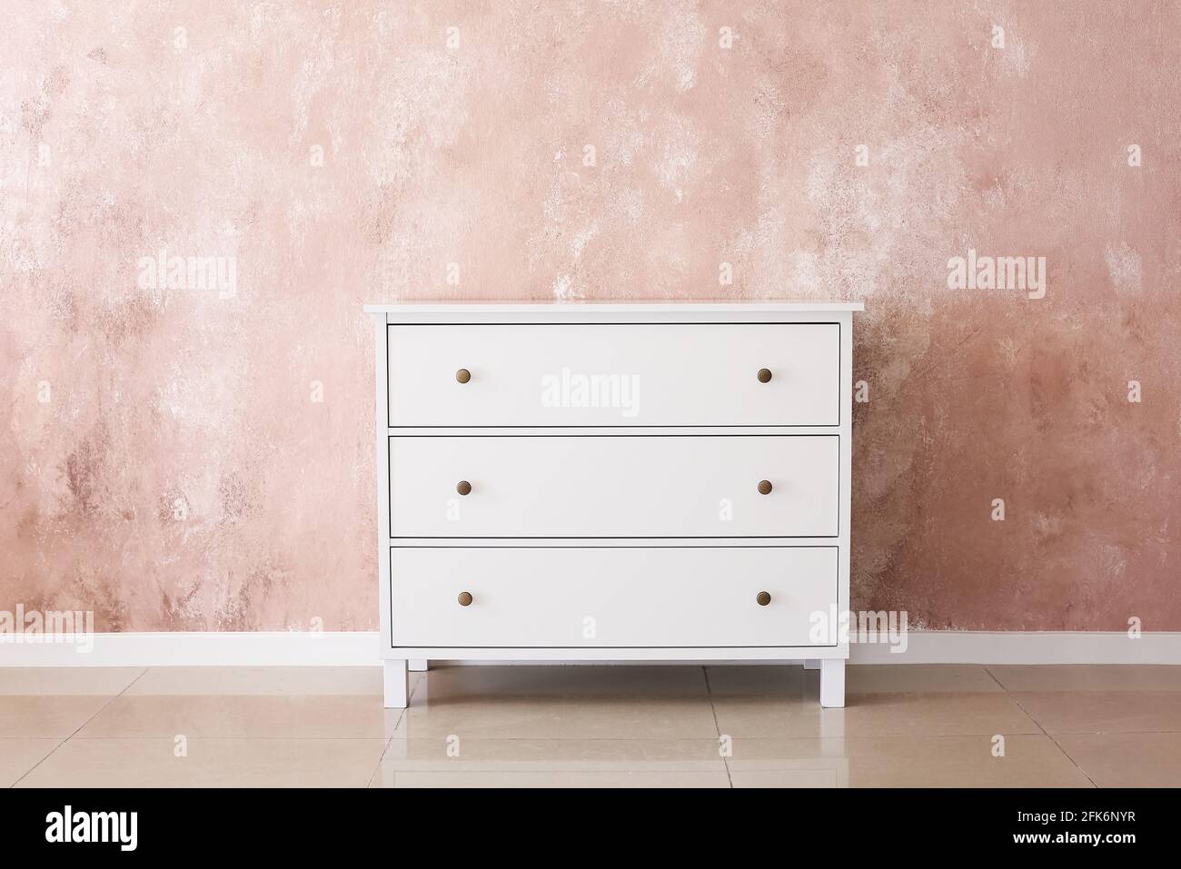 Stylish chest of drawers near color wall Stock Photo - Alamy