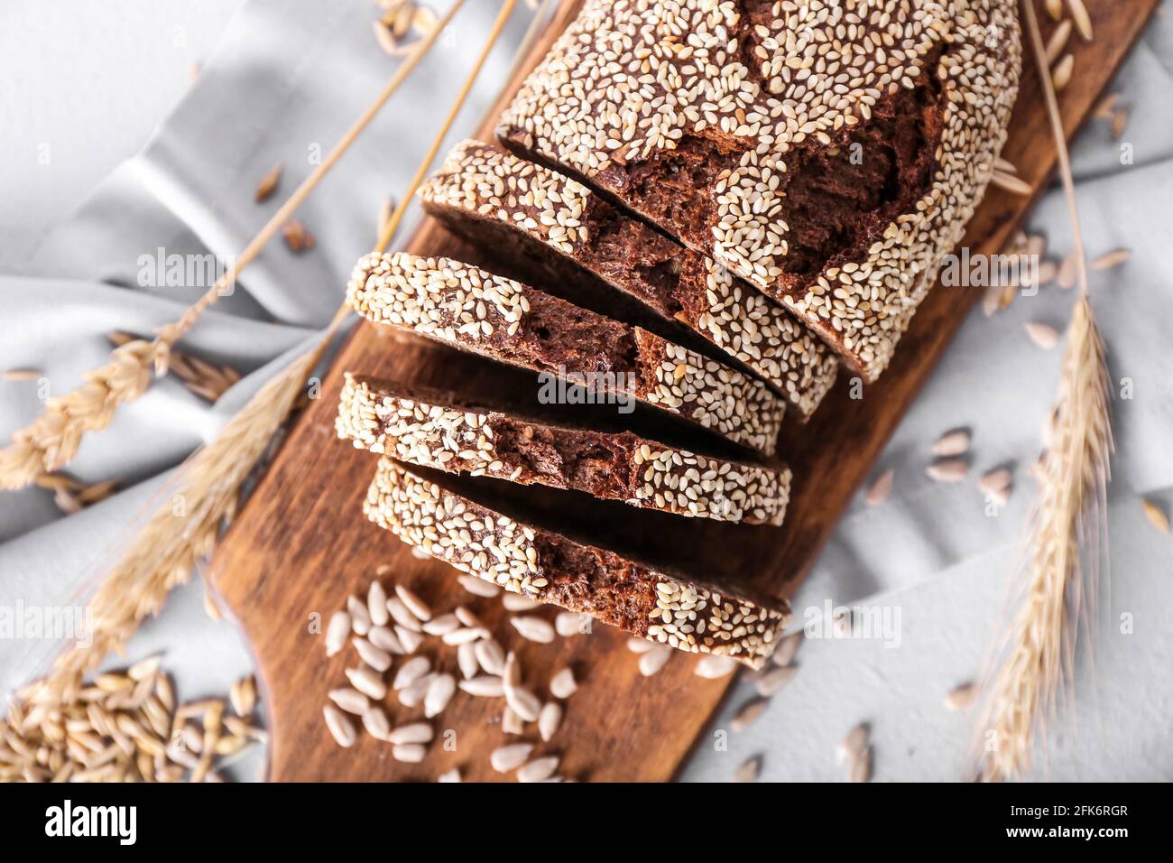 Board with fresh cut bread on light background Stock Photo - Alamy