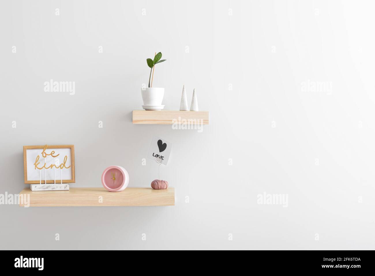 Shelves with alarm clock and decor on white wall Stock Photo Alamy
