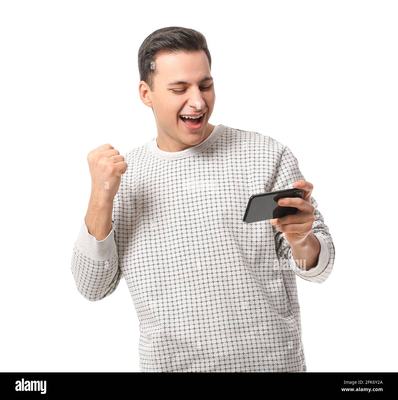 Happy young man with mobile phone on white background Stock Photo - Alamy