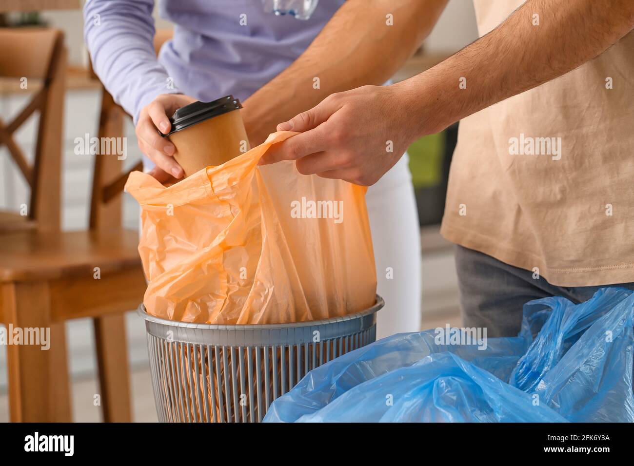 Young couple putting garbage in trash bin at home Stock Photo Alamy