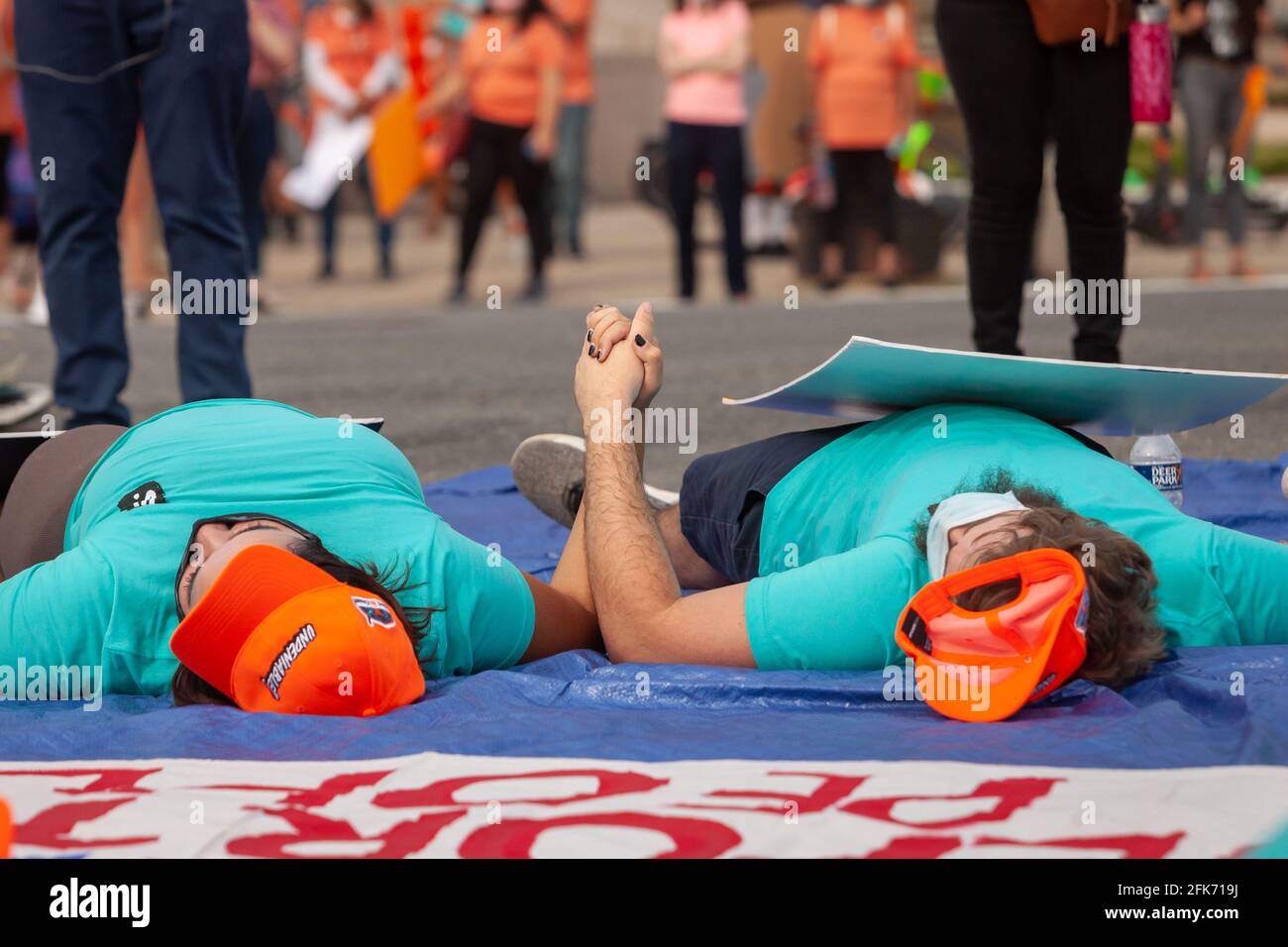 Washington, DC, USA. 28th Apr 2021.   Pictured: Immigrants with United We Dream lie in the street at one of the busiest intersections in Washington to demand an end to deportations and residency and/or citizenship for undocumented workers.  Credit: Allison C Bailey / Alamy Live News Stock Photo