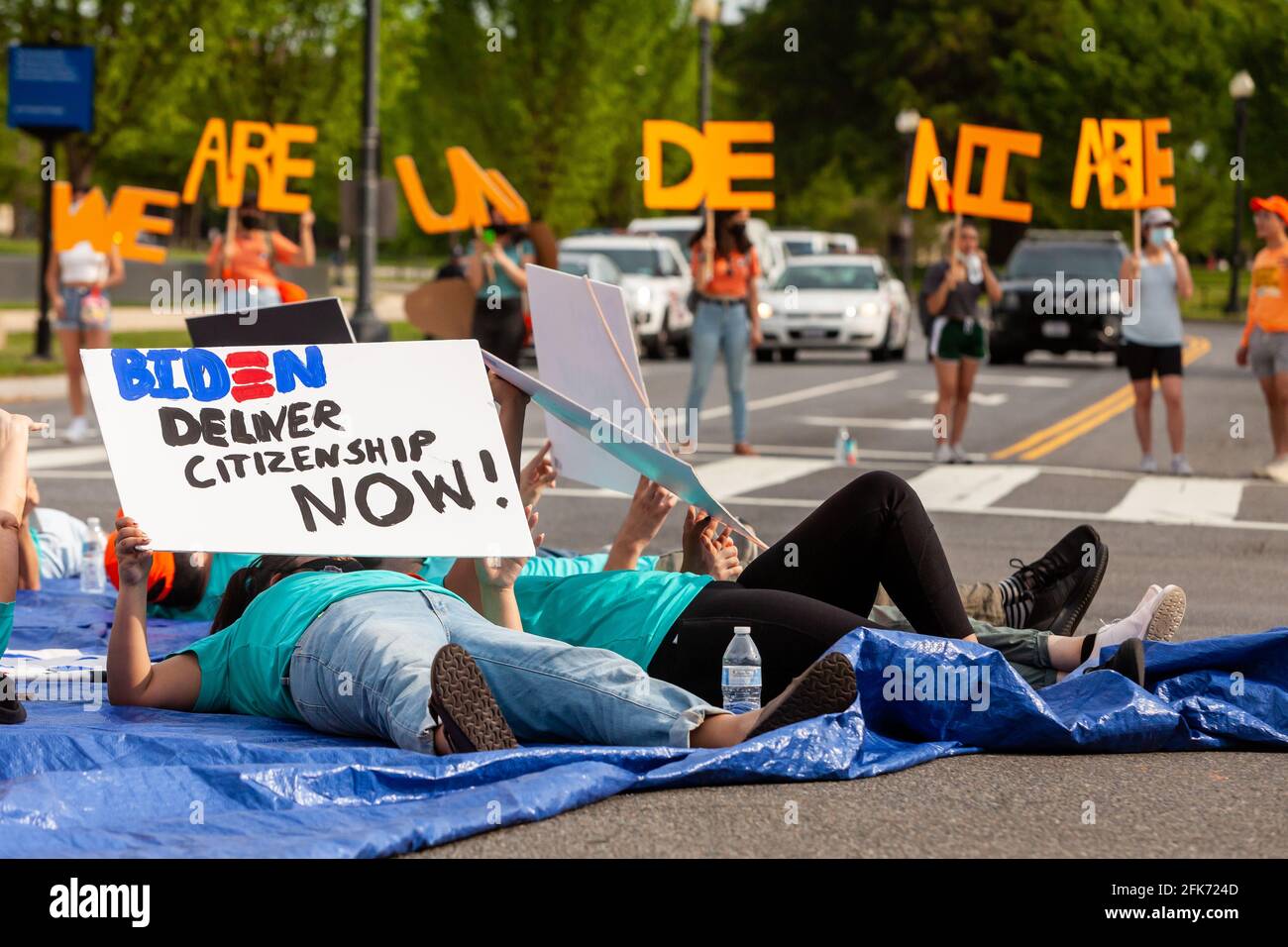 Washington, DC, USA. 28th Apr 2021.   Pictured: Immigrants with United We Dream lie in the street at one of the busiest intersections in Washington to demand an end to deportations and residency and/or citizenship for undocumented workers.  Credit: Allison C Bailey / Alamy Live News Stock Photo