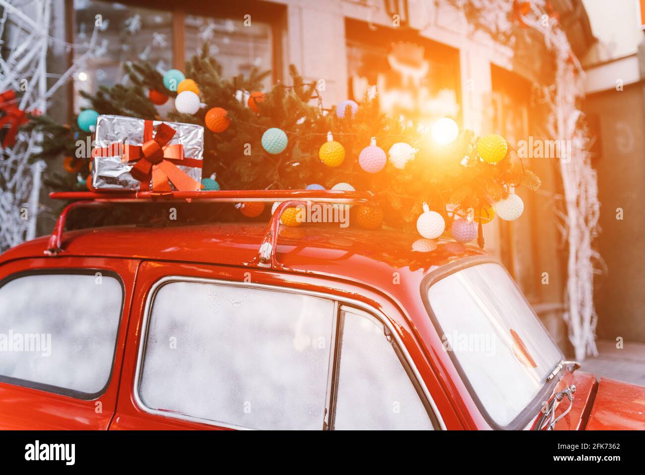 Red retro car with a Christmas tree fir tied to the roof Stock Photo ...