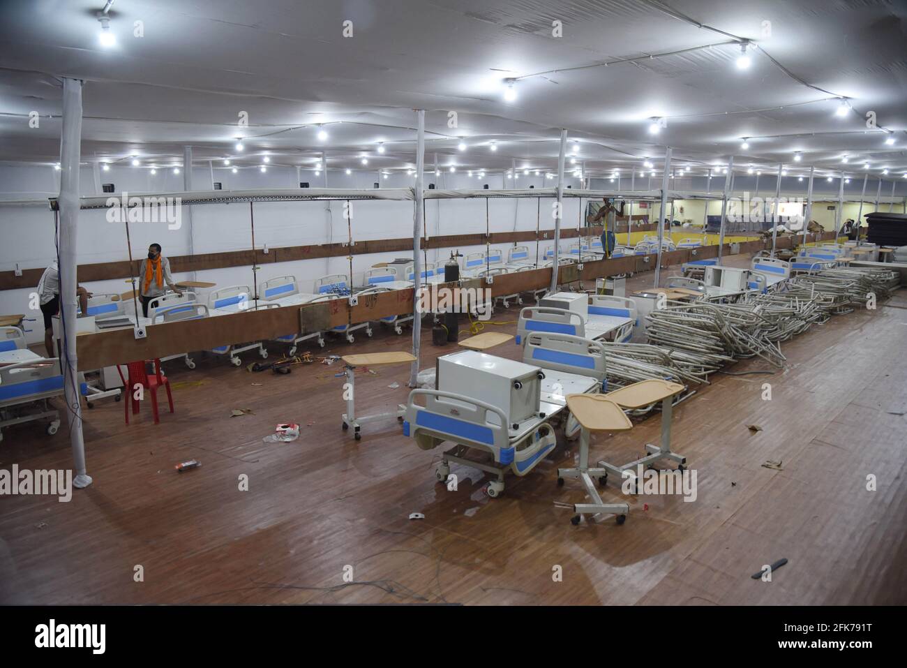 Patna, India. 28th Apr, 2021. Workers install beds in a sports complex which will be converted into a temporary care center for COVID-19 patients in Patna, India, April 28, 2021. India's COVID-19 tally surpassed 18 million, reaching 18,376,524 on Thursday, as a fresh high of 379,257 new cases were recorded during the past 24 hours, said the federal health ministry. As many as 3,645 deaths reported across the country since Wednesday morning, also the highest daily spike, took the total death toll to 204,832. Credit: Str/Xinhua/Alamy Live News Stock Photo