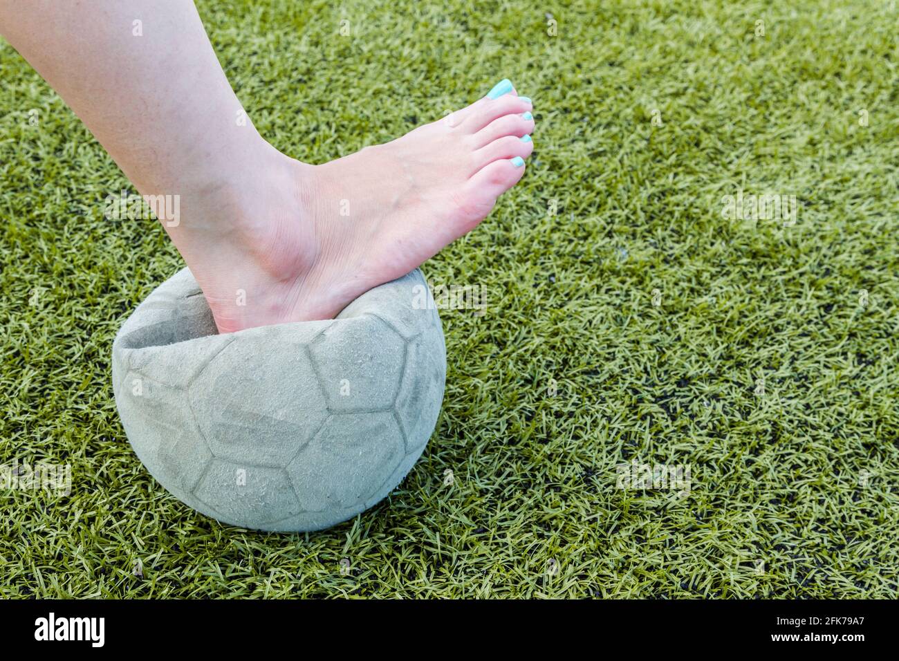 Girl Barefoot and old soccer ball background Stock Photo