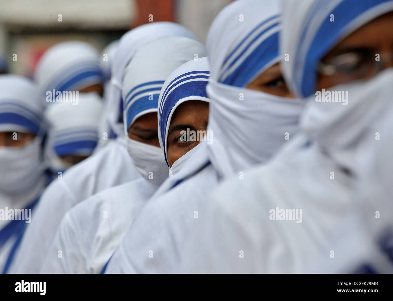Catholic nuns from the Missionaries of Charity, the global order of nuns founded by Saint Mother Teresa, wait in a line to cast their vote outside a polling station during the eight and final phase of West Bengal state election, amid the spread of the coronavirus disease (COVID-19) in Kolkata, India, April 29, 2021. REUTERS/Rupak De Chowdhuri Stock Photo