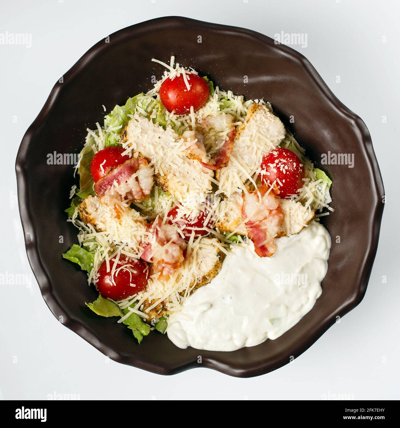 Caesar salad. Juicy slices of chicken steak, fresh lettuce, tomatoes, toasted bacon, parmesan and tender creamy dressing. Stock Photo