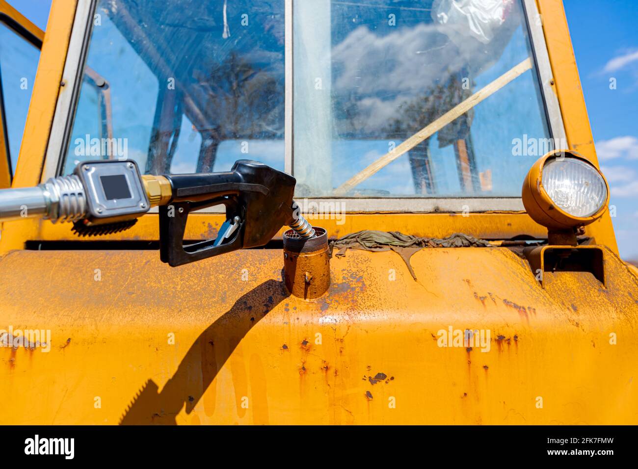 Fuel pump gun inserted in the reservoir of construction machine, pour