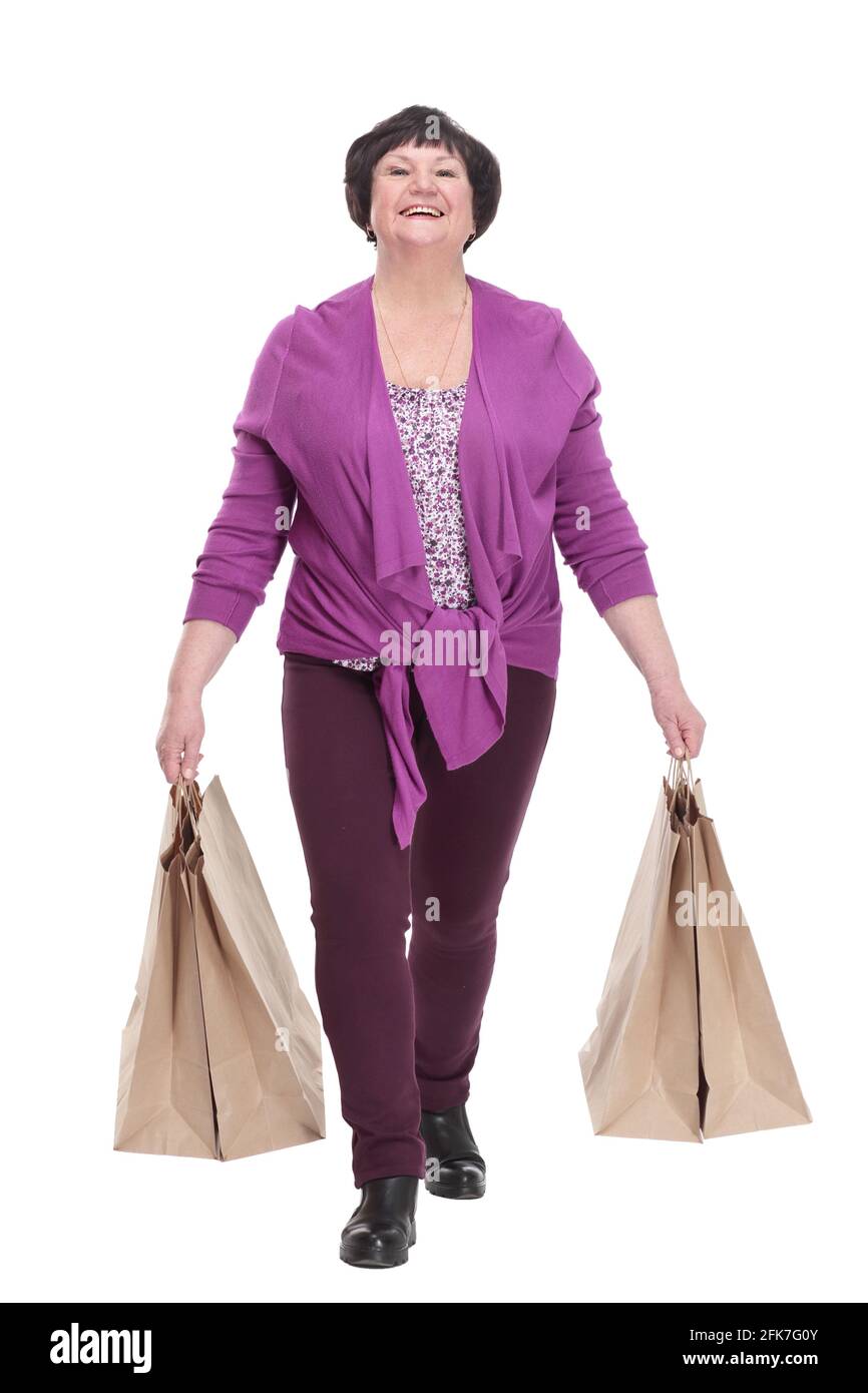 casual elderly woman with shopping bags striding forward Stock Photo