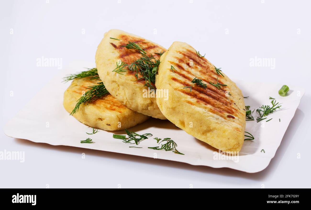 Fried potato pies. Patties with dill. Cheap recipe for homemade fried pies on a white background. Easy meal idea. Side view. Stock Photo