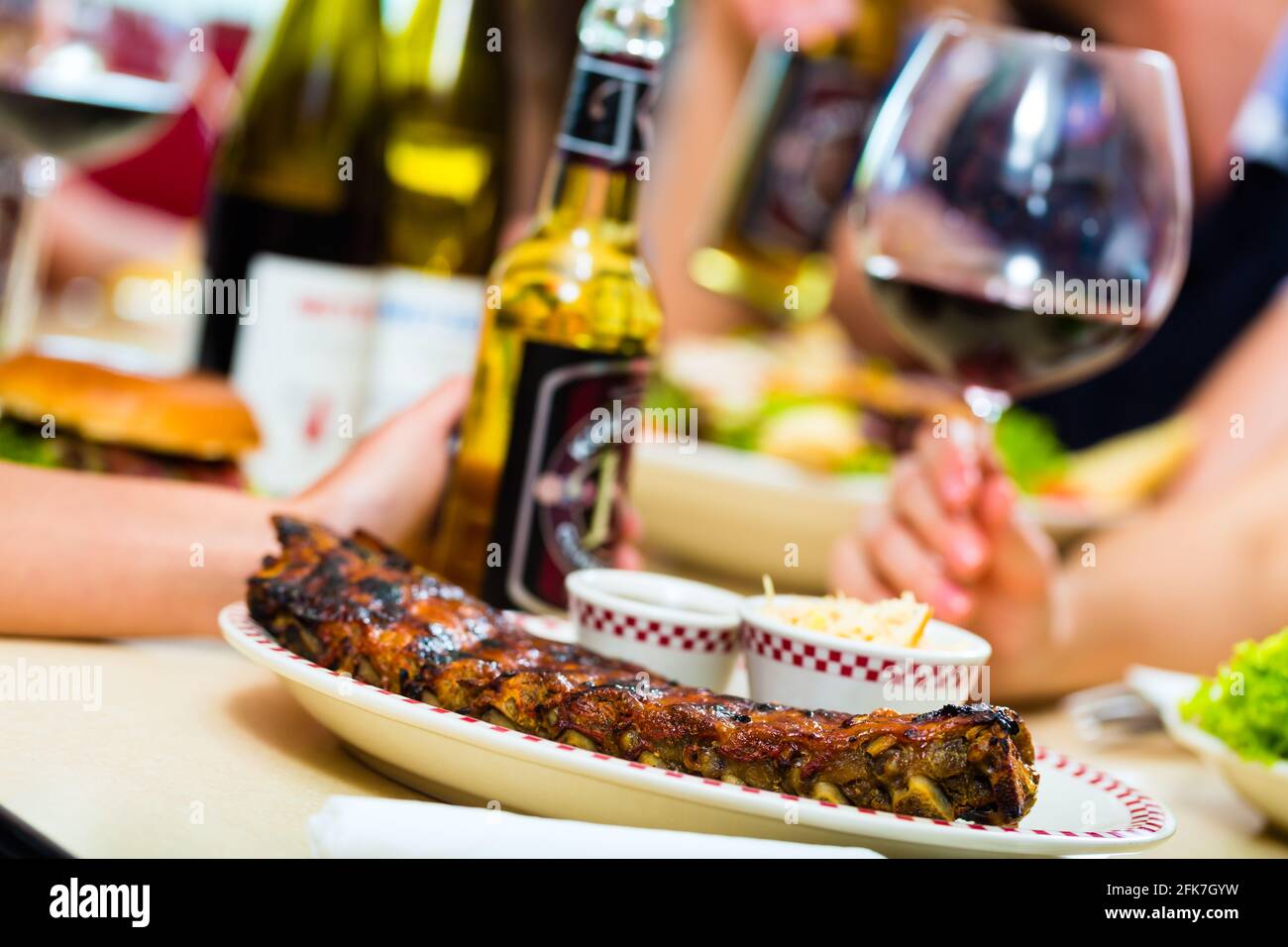 Friends or couples eating fast food and drinking beer and wine in a