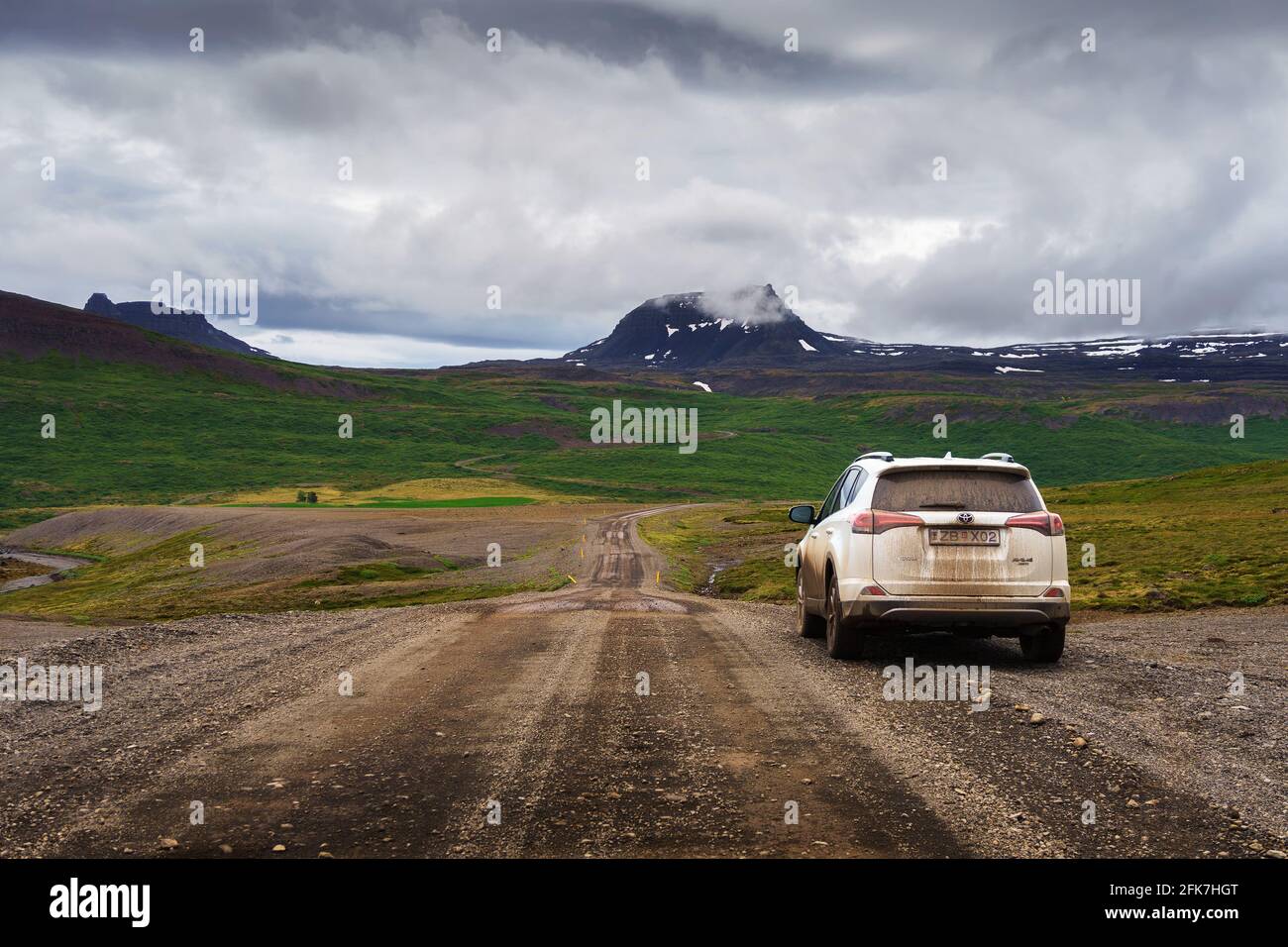 White rental SUV vehicle on the dirt road of Westfjords region in Iceland Stock Photo