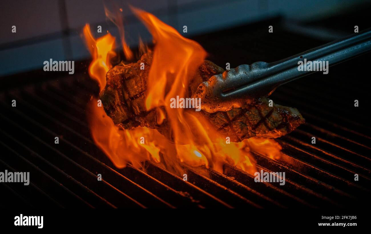 Close up view on Rib eye Steak On Grill With Rosemary Pepper And Salt
