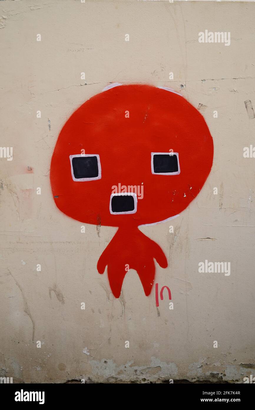 Alien Graffiti red figure with large head and square eyes and mouth Stock Photo
