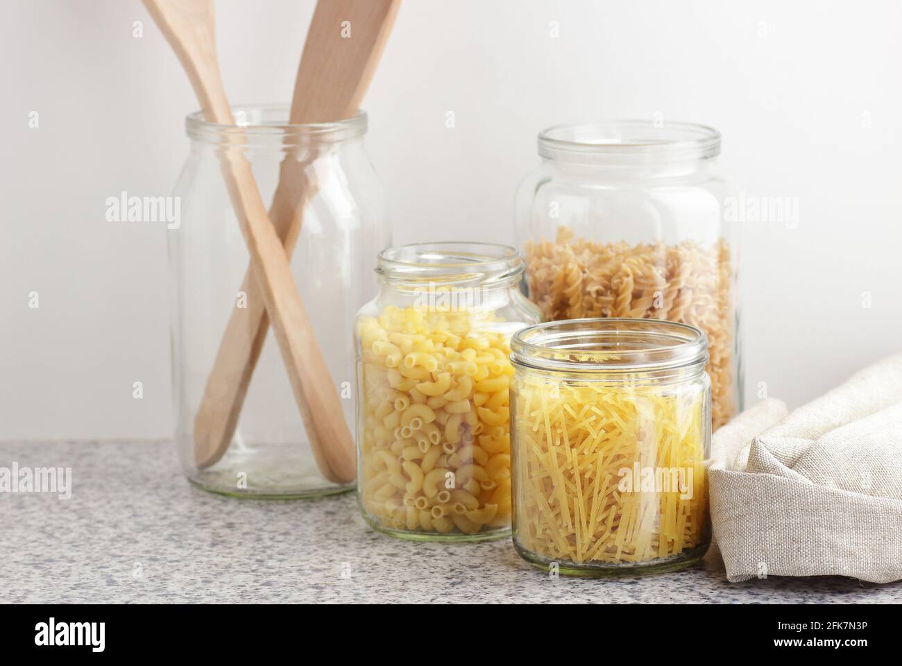 Variety of italian pasta in glass jars uncooked on white kitchen background, closeup, zero waste, eco friendly, balanced diet food, healthy clean eati Stock Photo