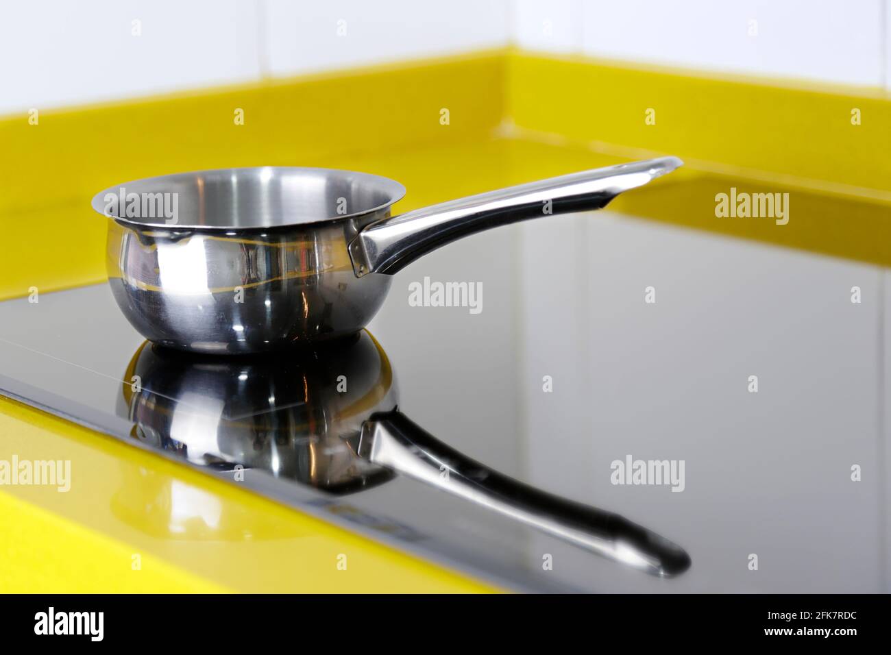 Little stainless steel pot in kitchen on the induction panel Stock Photo