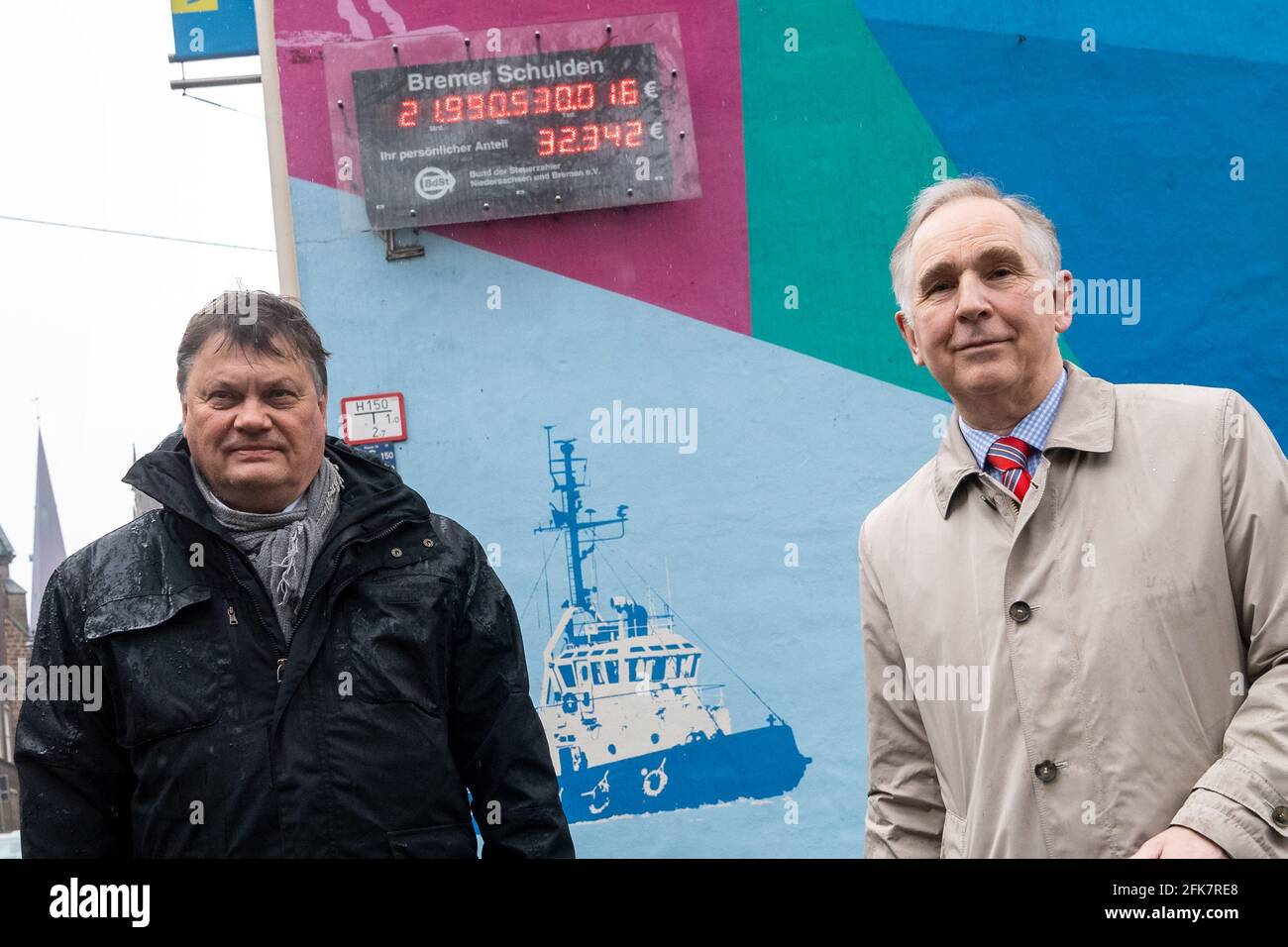 Bremen, Germany. 29th Apr, 2021. Dietmar Strehl (Bündnis90/Die Grünen, l), Bremen's Finance Senator, and Carl Kau, board member of the Bremen Taxpayers' Association, stand in front of Bremen's debt clock. The BdSt debt clock was programmed for the year 2021. Credit: Sina Schuldt/dpa/Alamy Live News Stock Photo