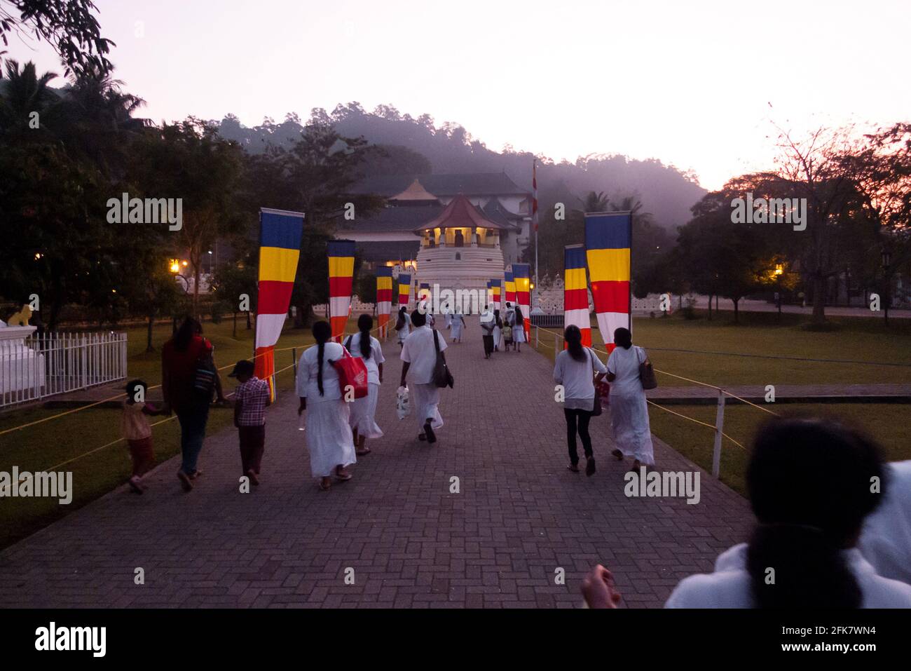 Kandy, Sri Lanka: a crowd of faithful dressed in white goes at dawn to the temple of sacred tooth relic (Sri Dalada Maligawa) Stock Photo