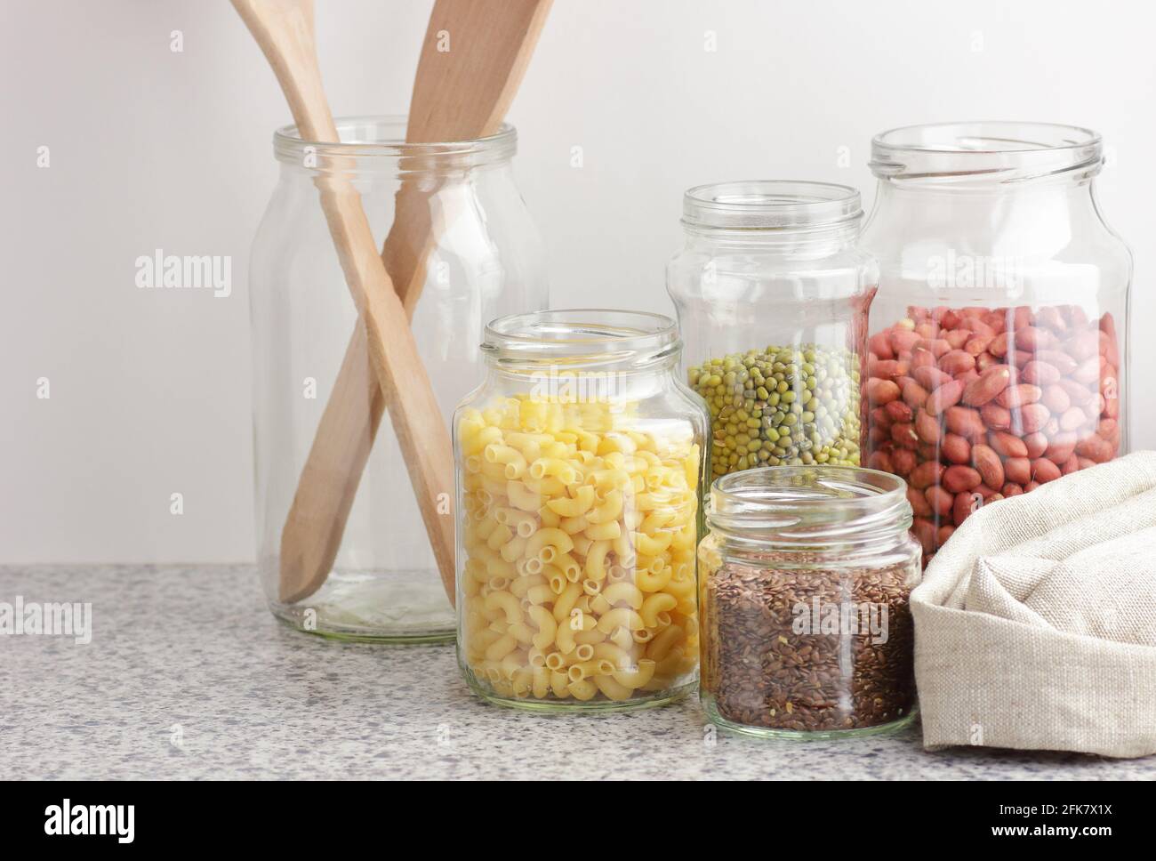Variety of cereals, grains, pasta, seeds in glass jars uncooked on white kitchen background, closeup, zero waste, eco friendly, balanced diet food, he Stock Photo