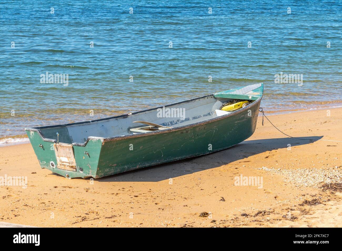 Abandoned fishing paddle boat on sand of sea bay. Quiet sea water level  within morning windless Stock Photo - Alamy