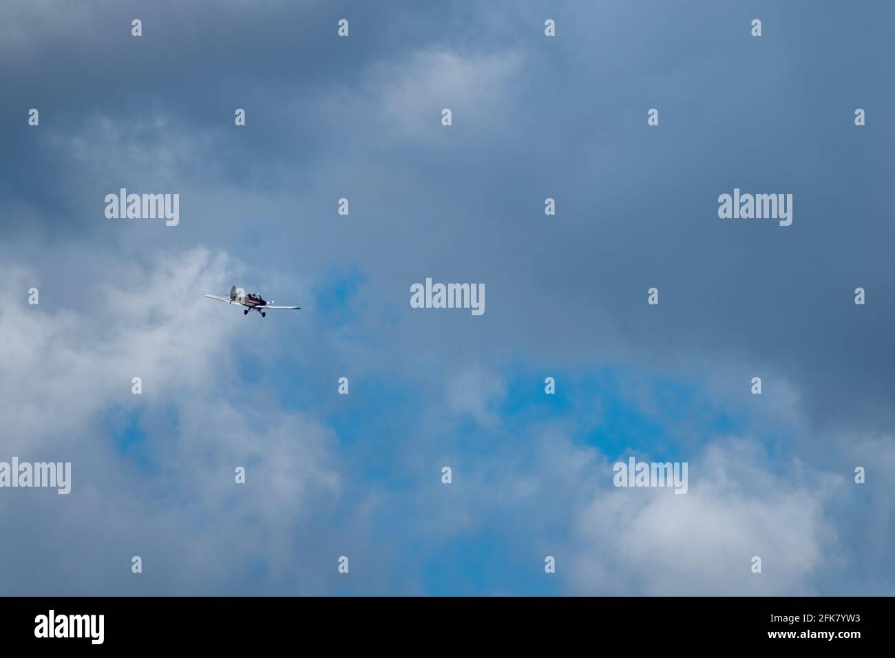 A single engine airplane flies in a cloudy sky over Pumicestone Passage, Queensland, Australia Stock Photo