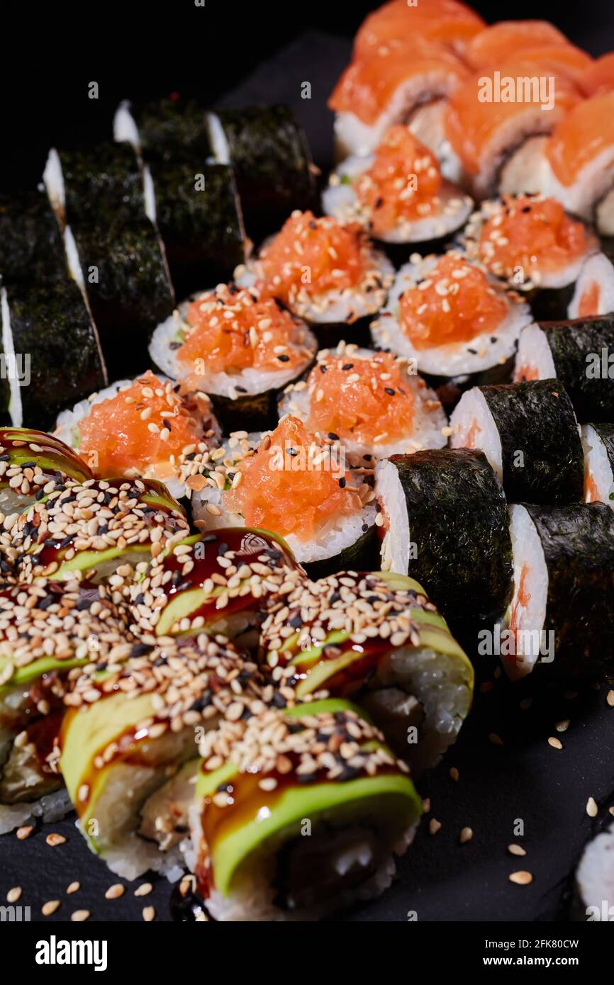 Close up set of sushi with salmon, cucumber, cream cheese, avocado and sesame seeds. Japanese traditional cuisine. Stock Photo