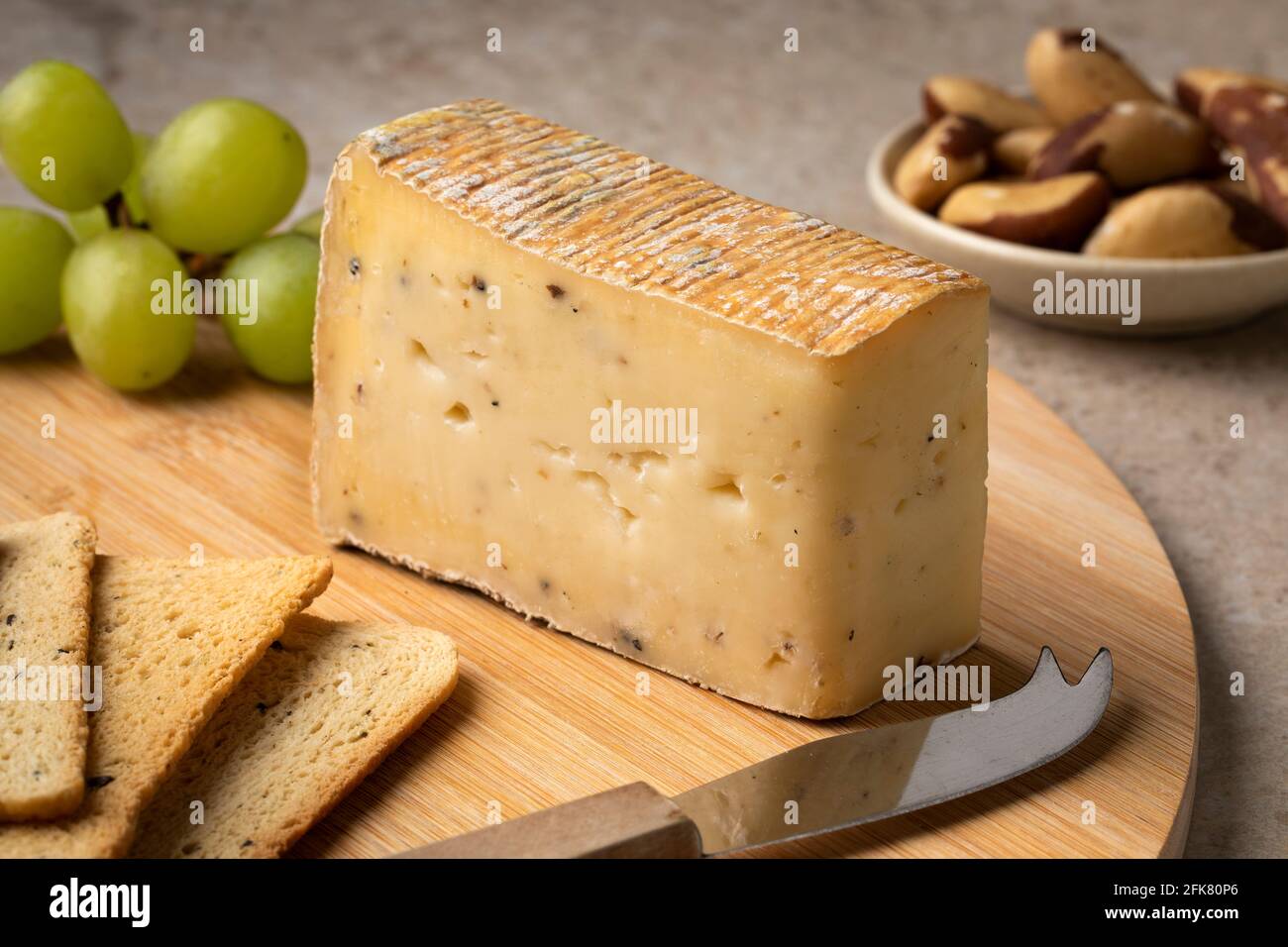 Cutting board with Italian Taleggio Tartufo cheese close up as a snack or appetizer Stock Photo