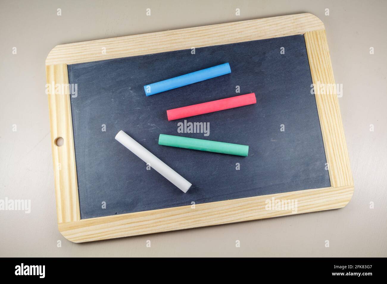 Chalkboard slate with red, green, blue and white chalks Stock Photo Alamy