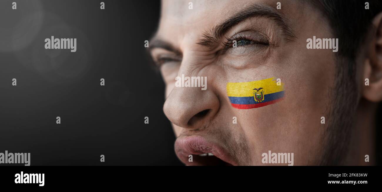 A screaming man with the image of the Ecuador national flag on his face Stock Photo