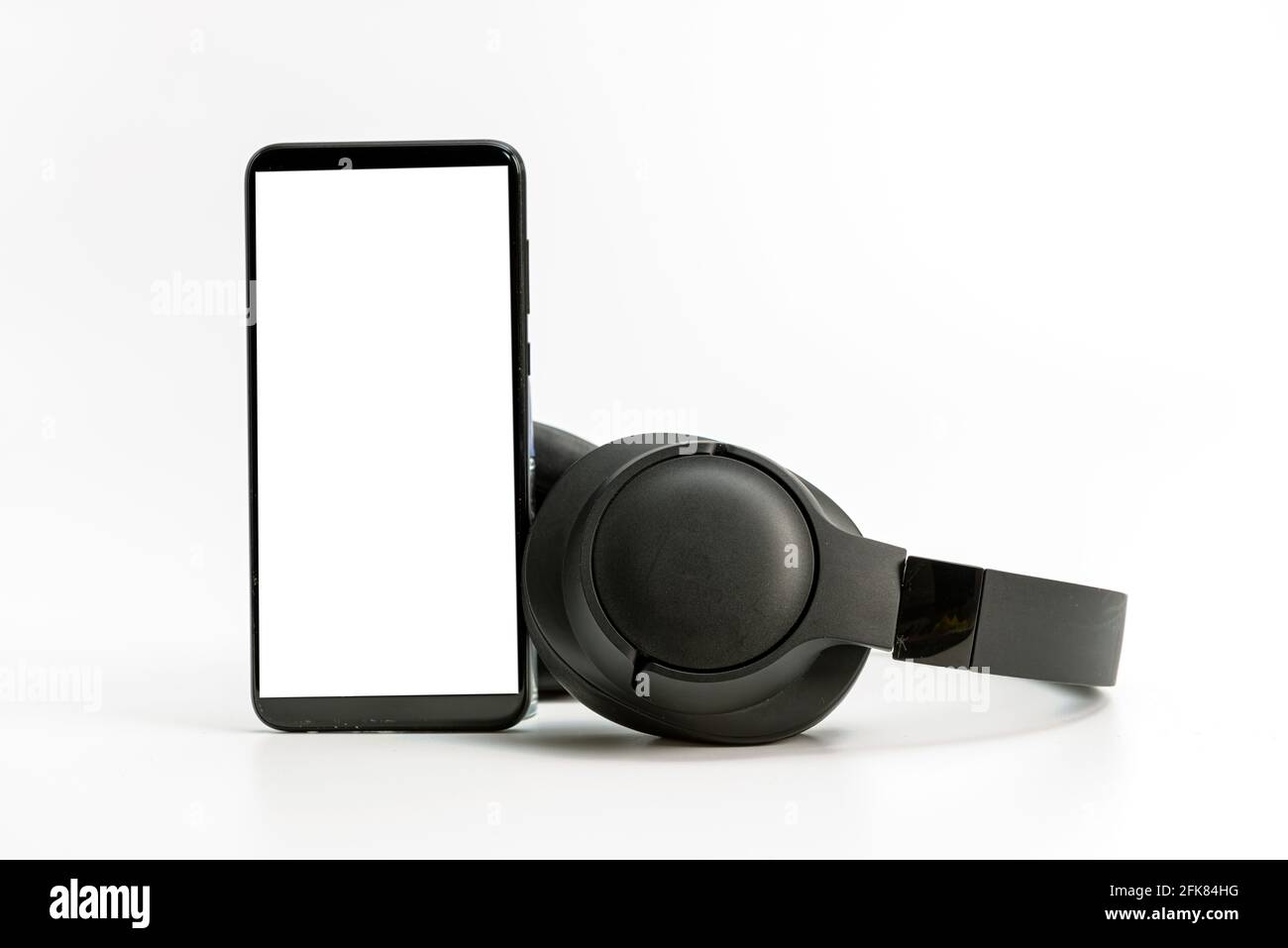 black wireless headphones and smartphone on white background, blank screen mockup, copy space Stock Photo