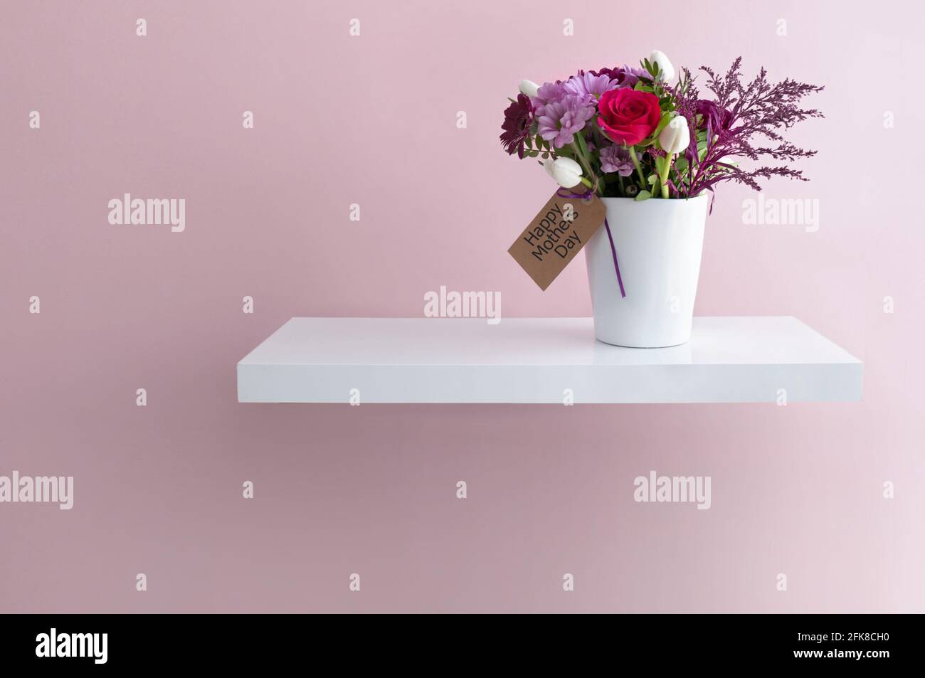 Mothers day flowers in a vase on a floating shelf Stock Photo