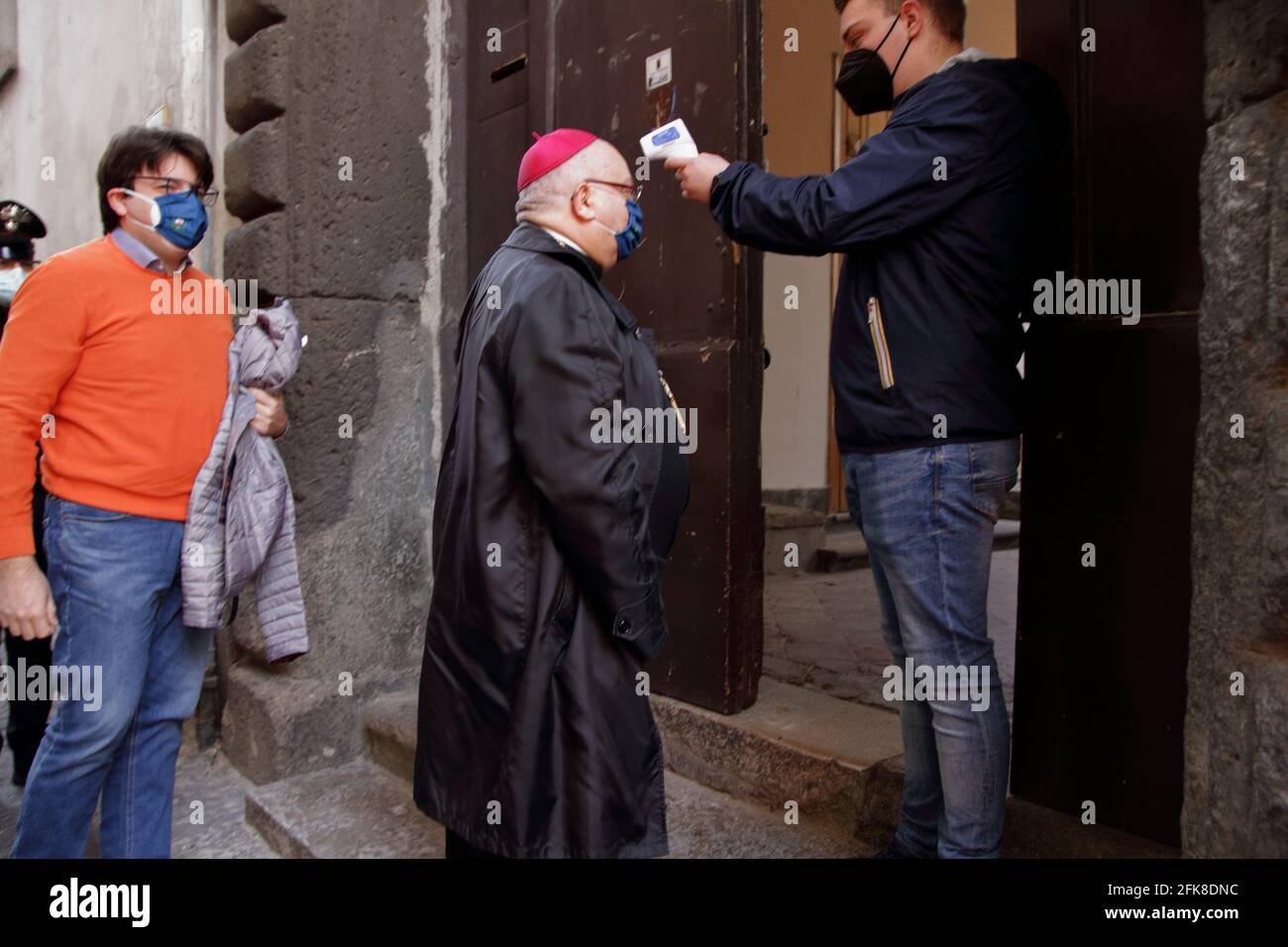The Bishop of the Diocese Nocera-Sarno with protective mask is entering the Sanctuary for the celebration of Holy Mass behind closed doors. Stock Photo