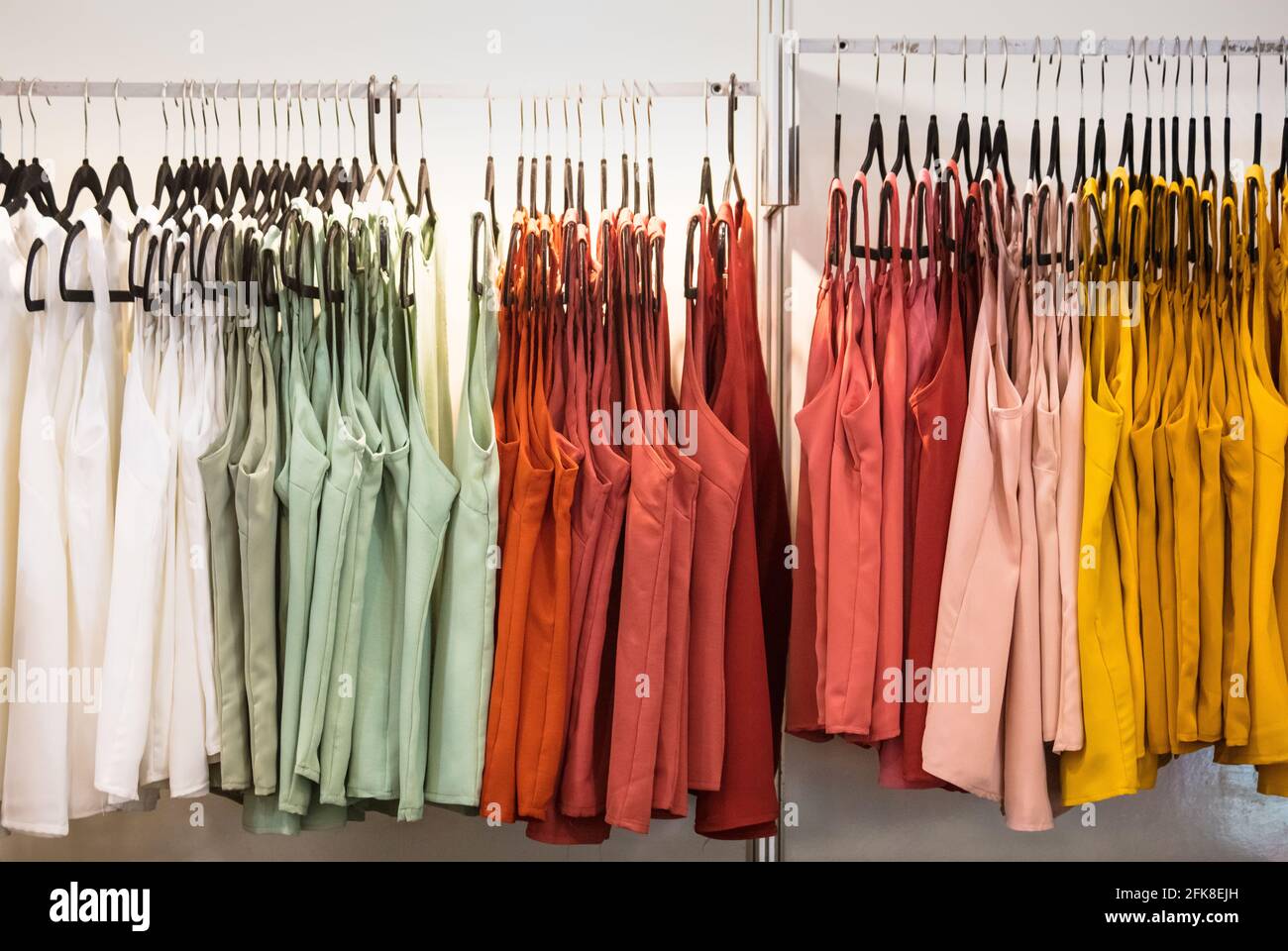 Line of colorful blouses on hangers in the store Stock Photo