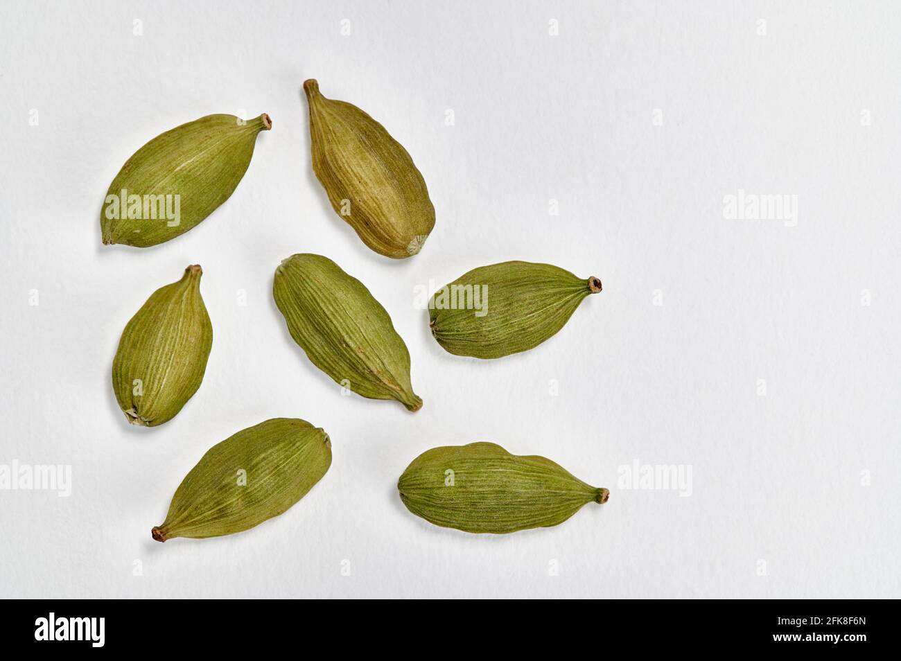 Closeup view of Green cardamom (Elettaria cardamomum) pods on a white background Stock Photo
