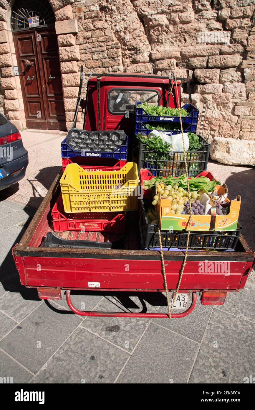 Ape Fahrzeug eines Gemuesehaendlers, beladen mit Obst und Gemuese, in der Altstadt von Assisi, Umbrien, Italien Stock Photo