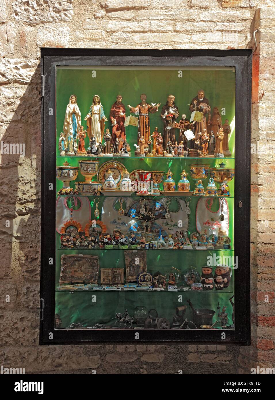 Schaufenster mit Heiligenfiguren, Devotionalien, in der Altstadt von Assisi, Umbrien, Italien Stock Photo