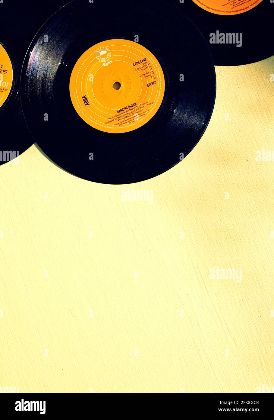 Dancing Queen by Abba 7 inch 45 rpm vinyl record on wooden yellow background outdoors. Concept of retro, nostalgia, yesteryear vintage Stock Photo