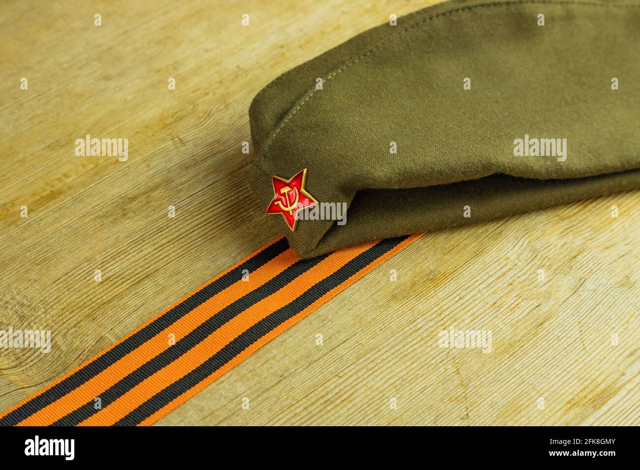 Military cap and George ribbon on wooden background. 9 May Victory Day holiday card concept. Stock Photo