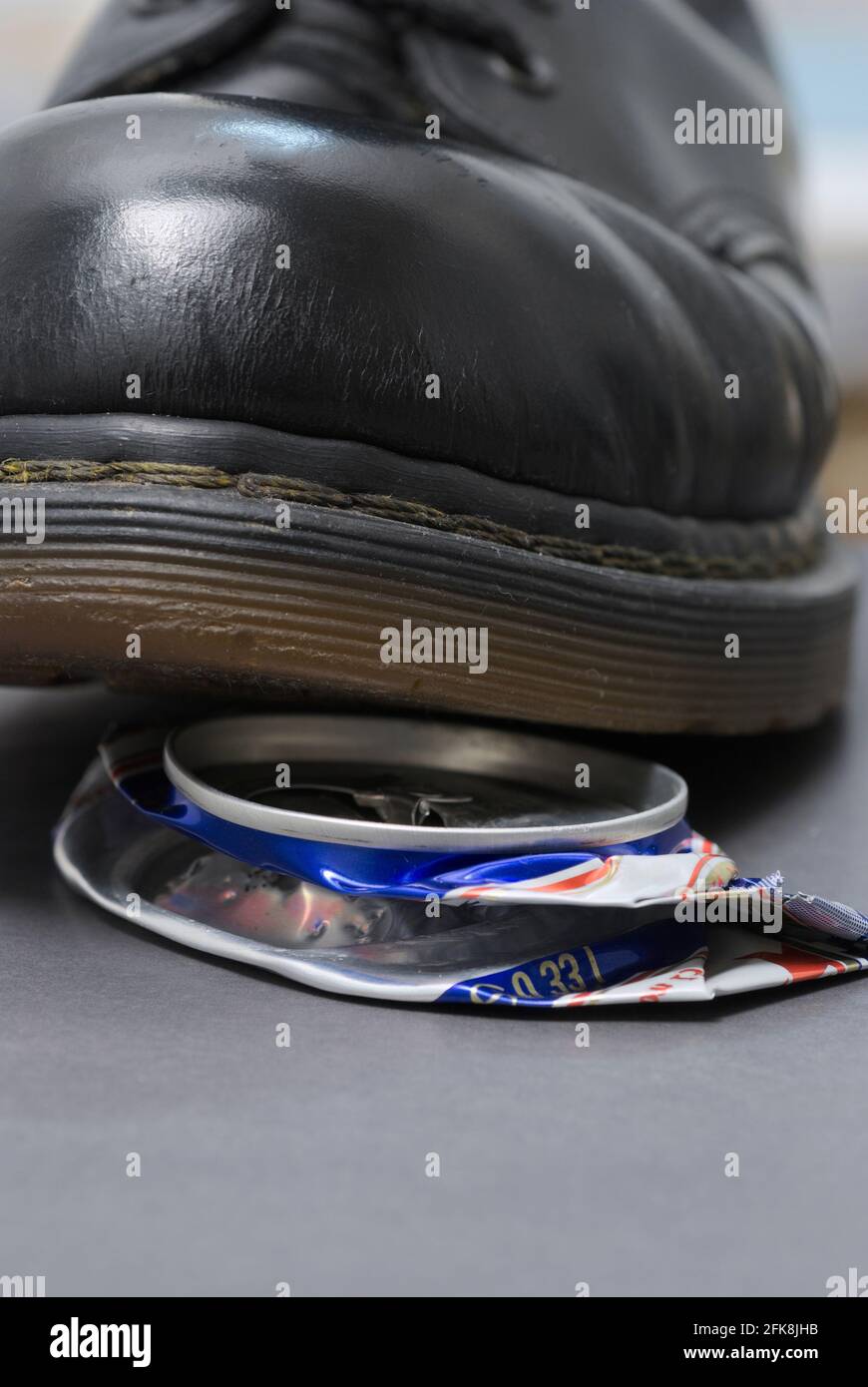 crushing empty beverage can with boot Stock Photo Alamy