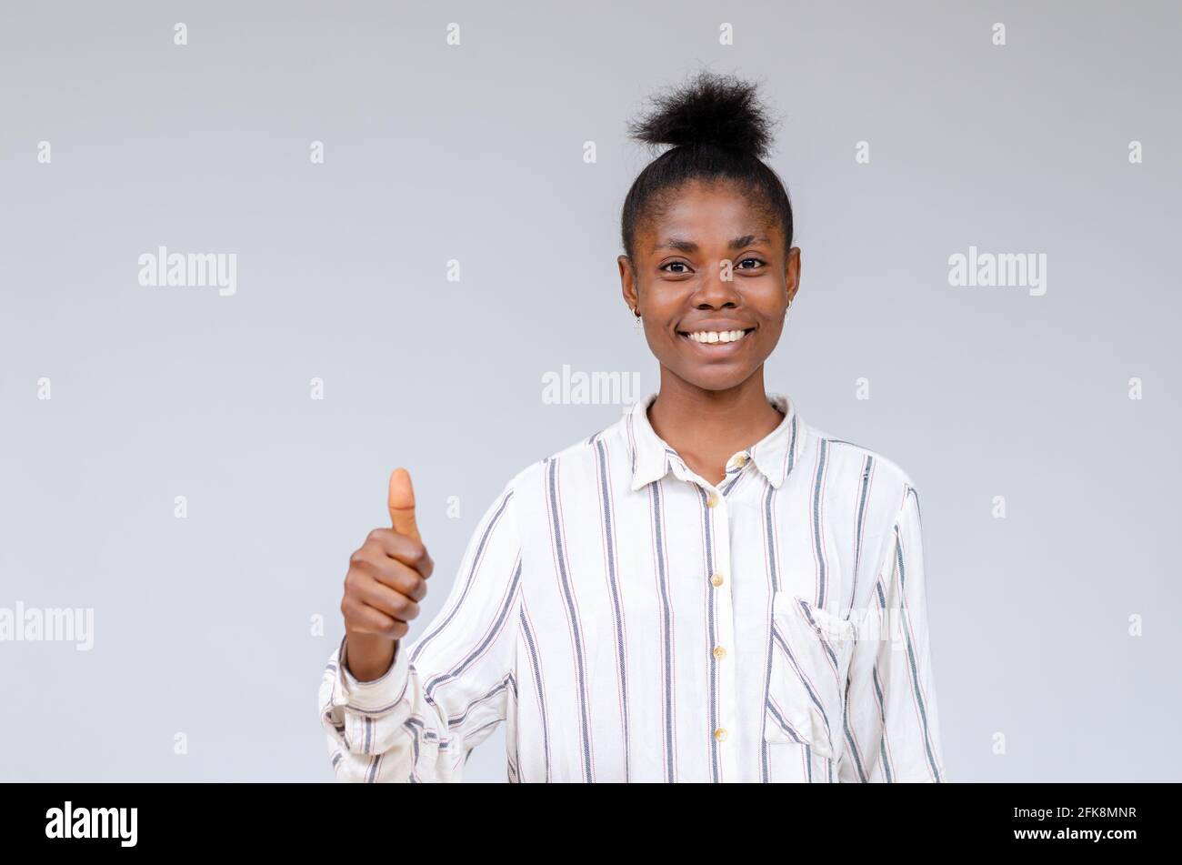 Shot of a young pretty African girl smiling at camera thumb up Stock ...