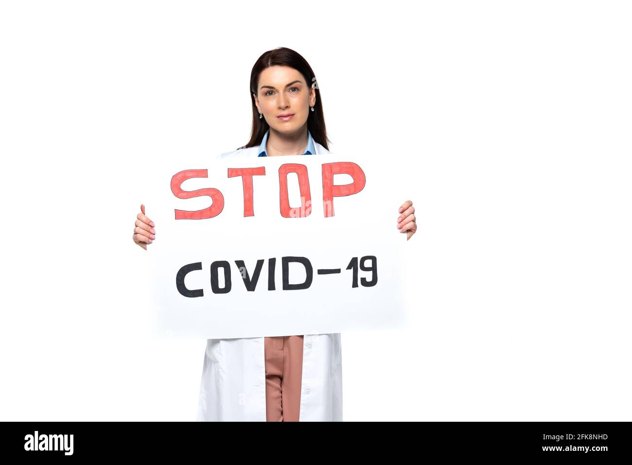 Brunette doctor in white coat holding placard with stop covid-2019 ...