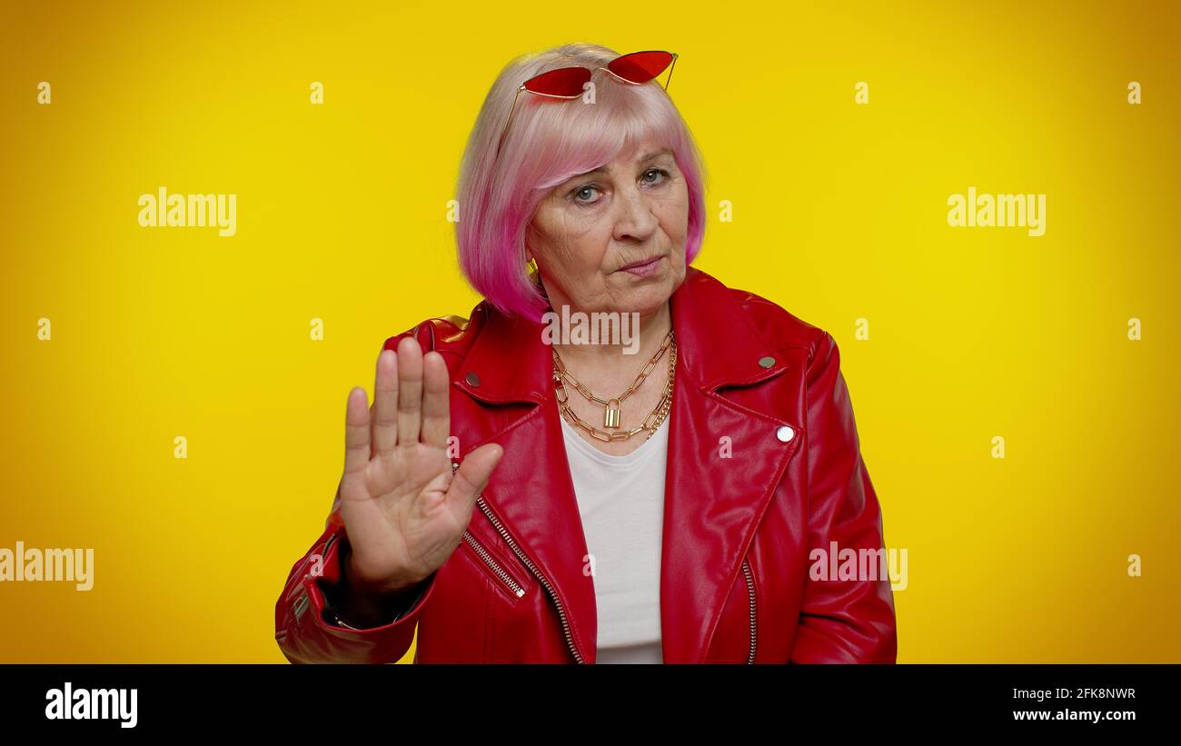 Elderly granny woman warning with admonishing finger gesture, saying no, be careful, avoid danger Stock Photo