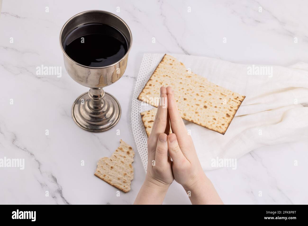holy communion chalice with wine and bread. Lord's supper and hands folded in prayer Stock Photo