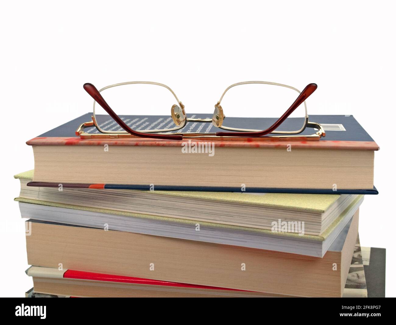 Stack of books and reading glasses against white background Stock Photo