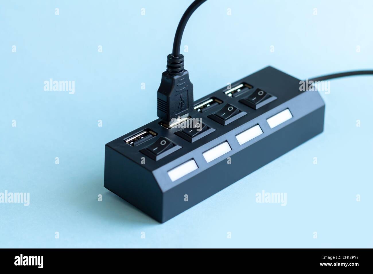 Black USB hub with usb cable plug on light blue background Stock Photo -  Alamy