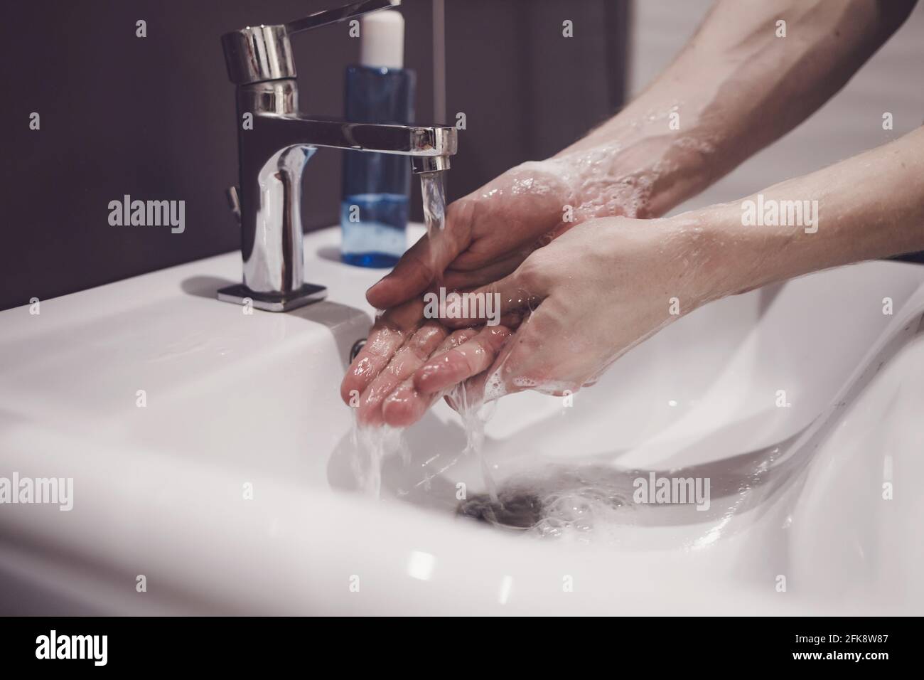 man showing hand hygiene washing hands with soap in hot water for